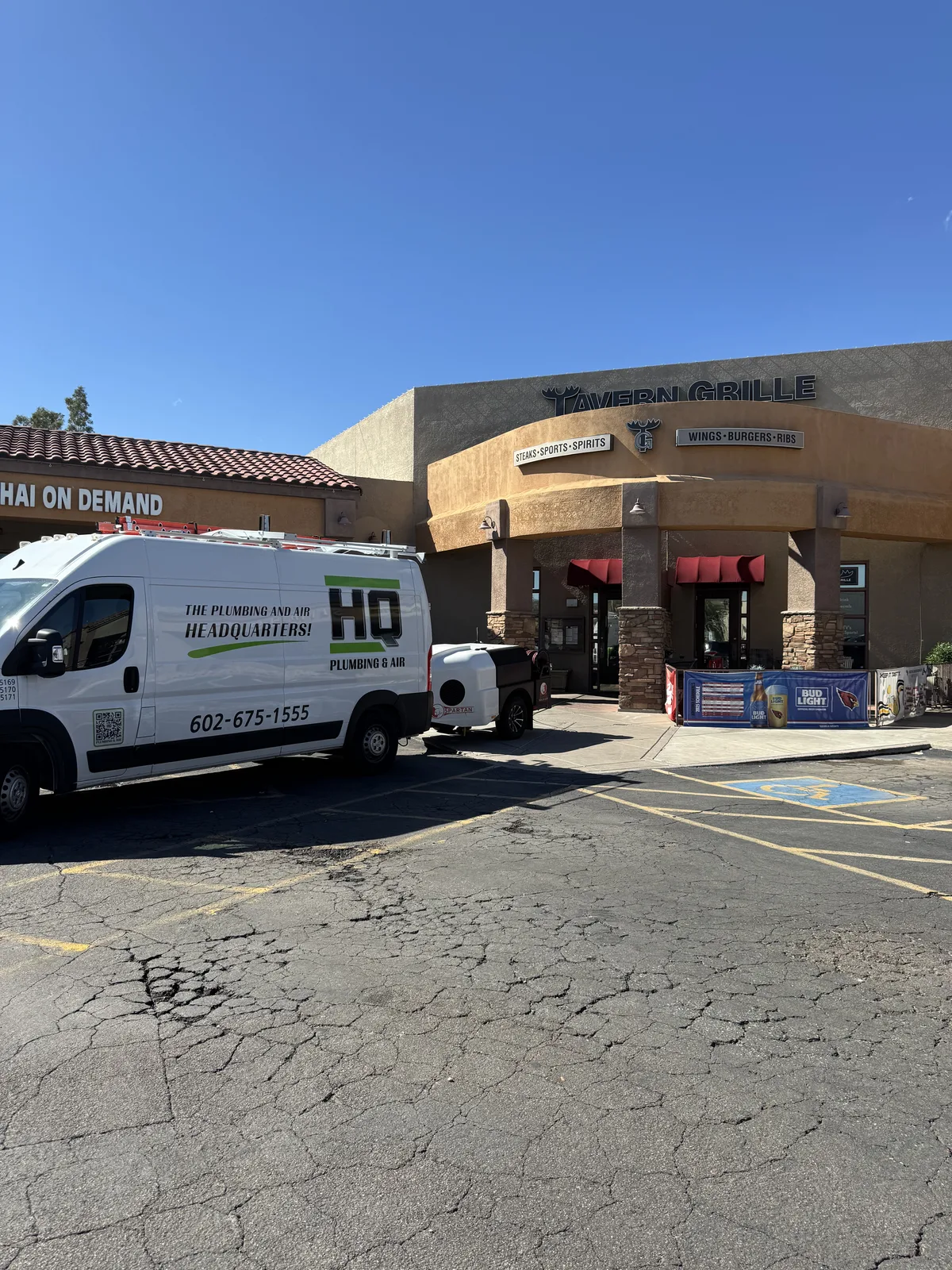 HQ Plumbing van parked outside a Phoenix restaurant on a commercial drain cleaning call