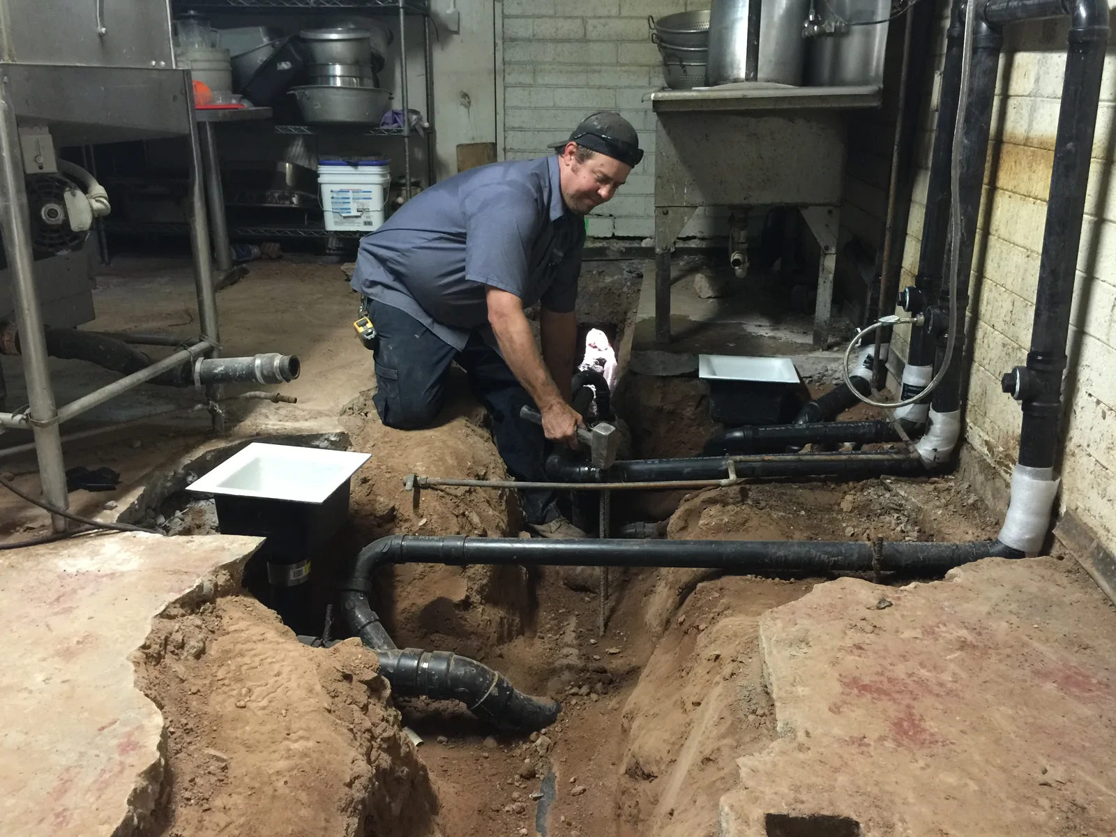 HQ Plumbing technician excavating and repairing an underground sewer line at a Phoenix commercial property